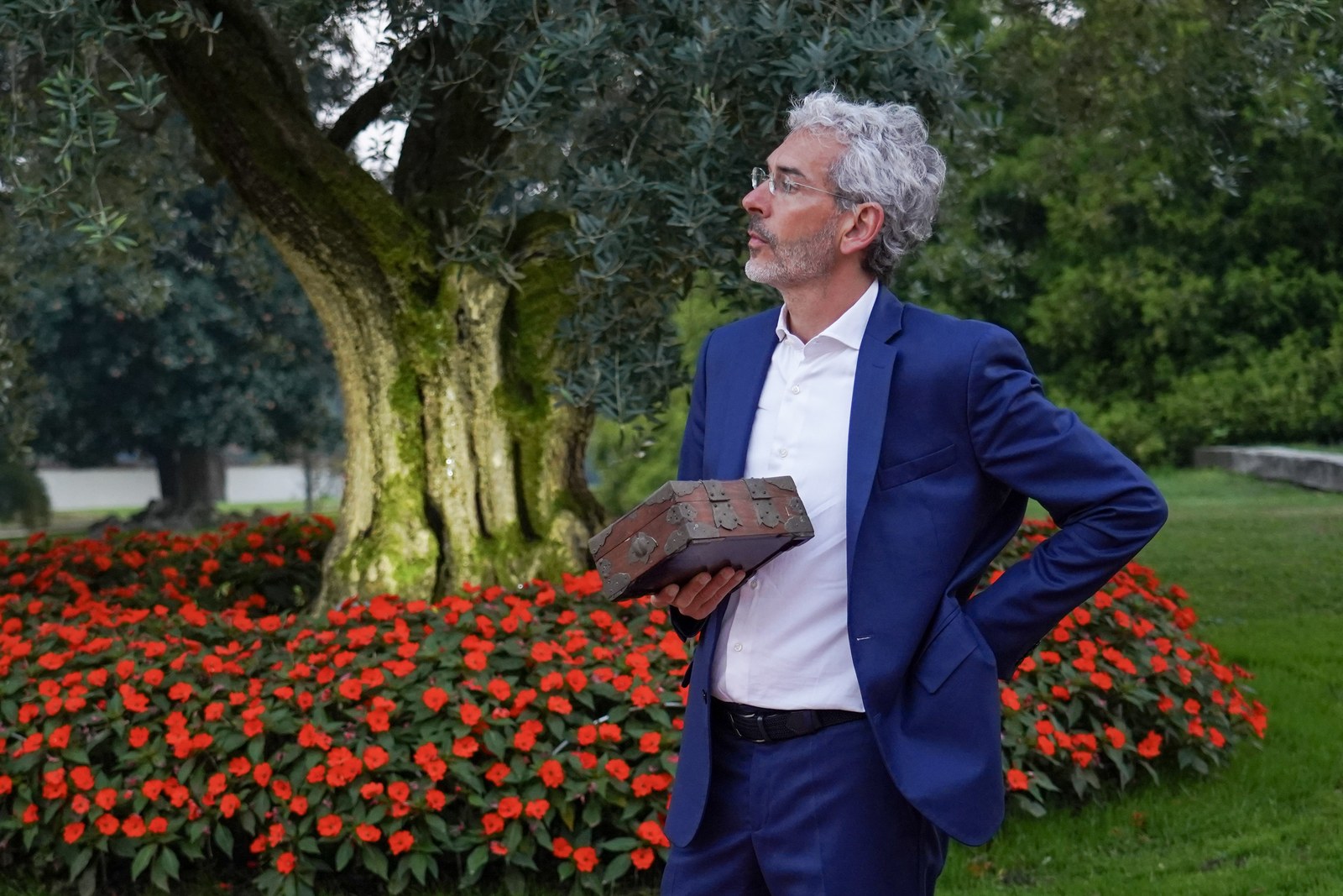 Federico Olivati all'aperto, in giacca blu, davanti a un ulivo